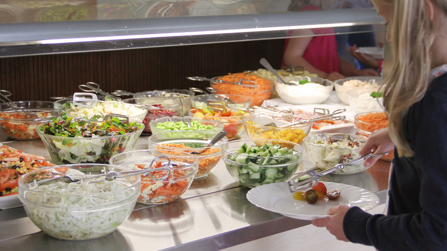 Barn vid salladsbuffé, lägger upp på tallrik