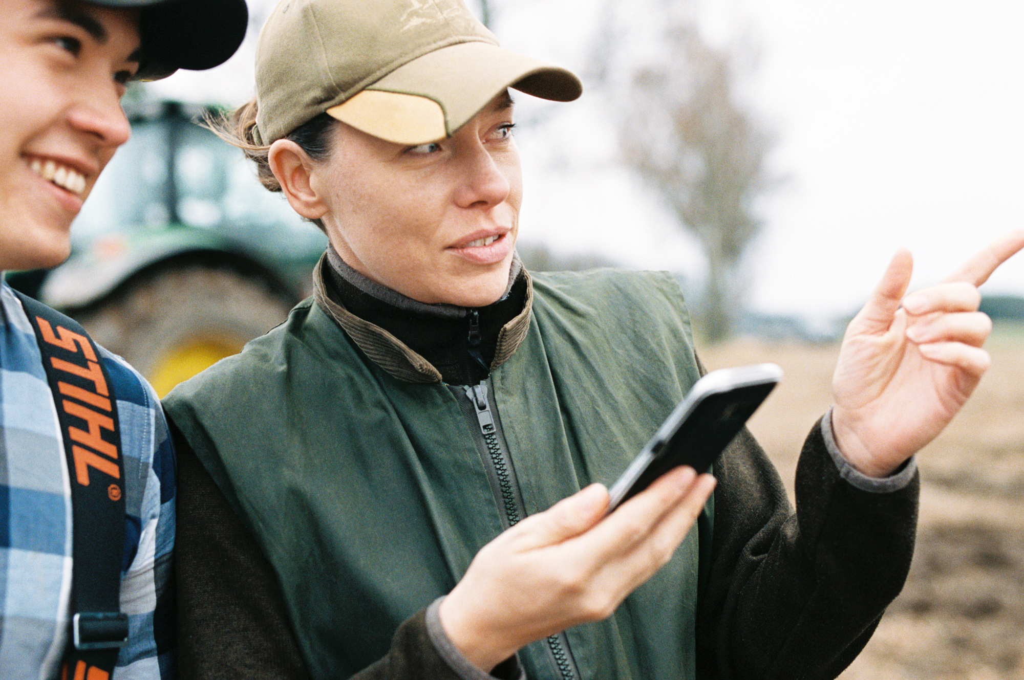 Två unga kvinnor  som tittar ut över åkermark