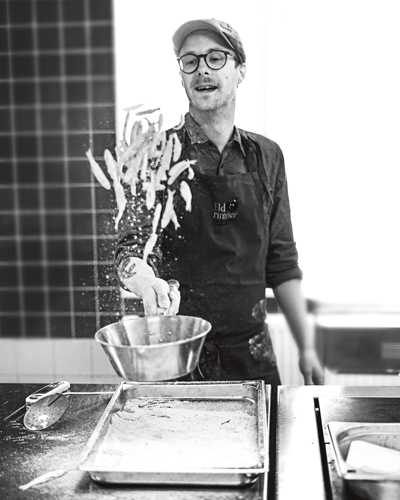 Viktor kastar upp mörtar i luften ur bunke i stål.