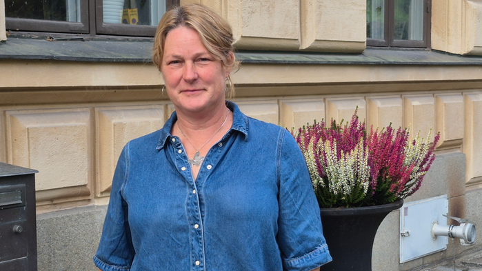 Sara Österman har blå skjorta och står vid odlad ljung