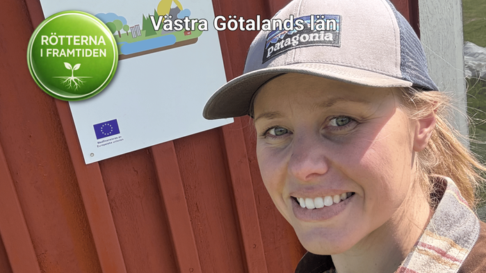 Johanna Wiberg har beige keps och står vid röd ladugård