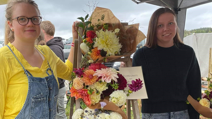 Emma Svensson och Sofia Warefelt bredvid ett blomsterarrangemang.