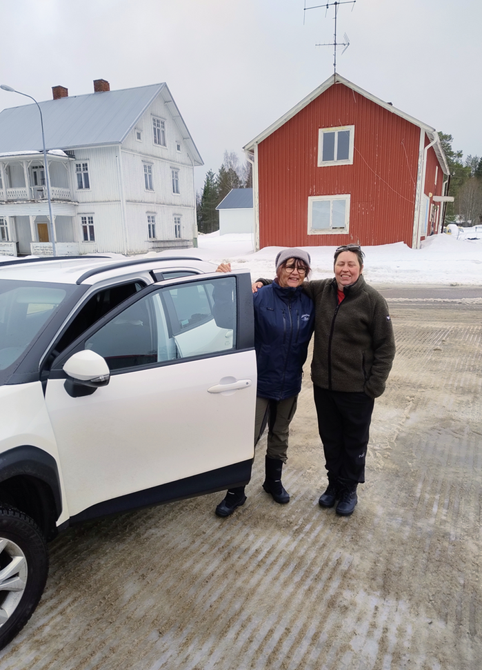 Två kvinnor vid en bil.