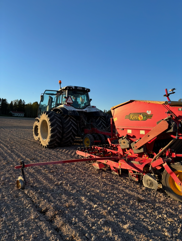 En röd traktor på åker