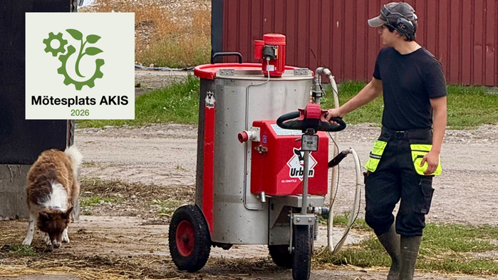 Ung lantbrukare drar en röd maskin medan en hund springer bredvid 