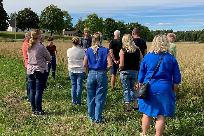 Bild från fältbesök. En grupp med människor står på ett odlat fält.